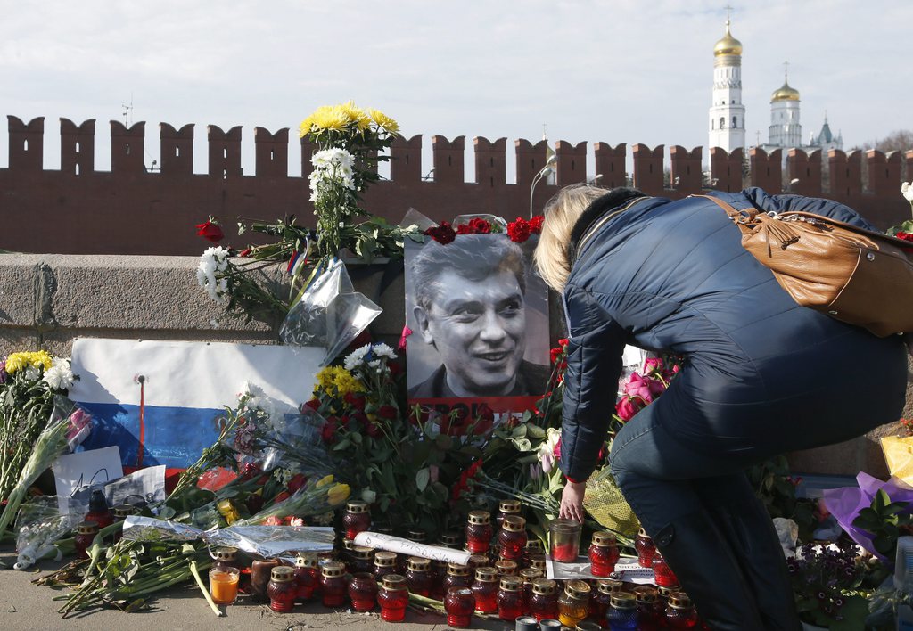 epa04654645 Russian people continue to lay flowers to the place of murder of Russian opposition politician Boris Nemtsov near the Kremlin on Grand Moskvorestsky bridge in Moscow, 09 March 2015. Five suspected in the murder have  been earlier arrested, one died during detention and two more arrested yesterday. All of them are Chechens.  EPA/SERGEI CHIRIKOV
