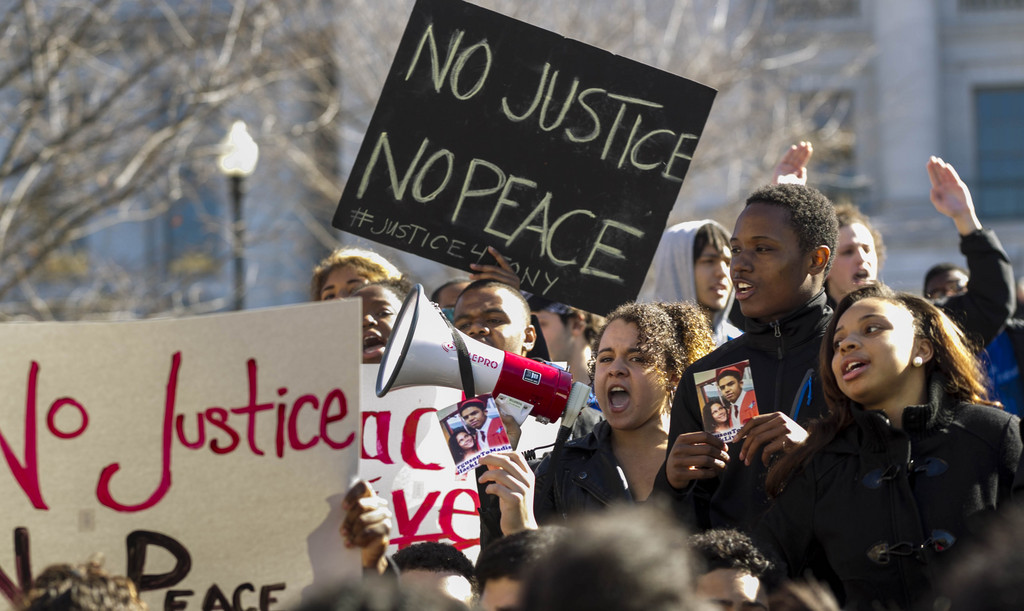 Demonstrators protest the shooting of Tony Robinson outside of the state Capitol Monday, March 9, 2015, in Madison, Wis.   Robinson, 19, was fatally shot Friday night by a police officer who forced his way into an apartment after hearing a disturbance while responding to a call. Police say Robinson had attacked the officer. (AP Photo/Andy Manis)