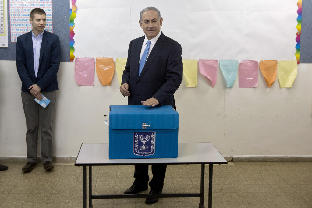 Israeli Prime Minister Benjamin Netanyahu casts his vote during Israel's parliamentary elections in Jerusalem, Tuesday, March 17, 2015. Israelis are voting in early parliament elections following a campaign focused on economic issues such as the high cost of living, rather than fears of a nuclear Iran or the Israeli-Arab conflict. (AP Photo/Sebastian Scheiner, Pool)