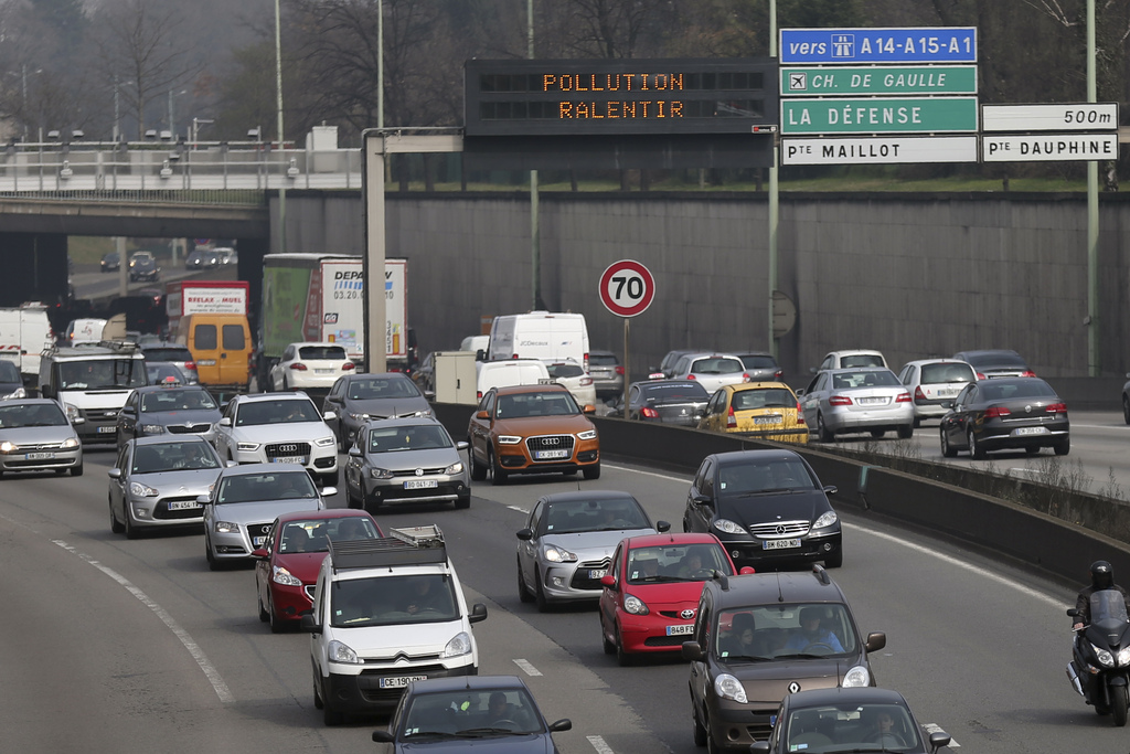 A display board reading, "Pollution Slow Down" flashes on a ring road around Paris, France, Wednesday, March 18, 2015. Paris police have lowered the speed limit and ordered a halt to burning of trash as part of emergency measures triggered by a spike in air pollution, months before the city hosts a major international climate conference. (AP Photo/Francois Mori)