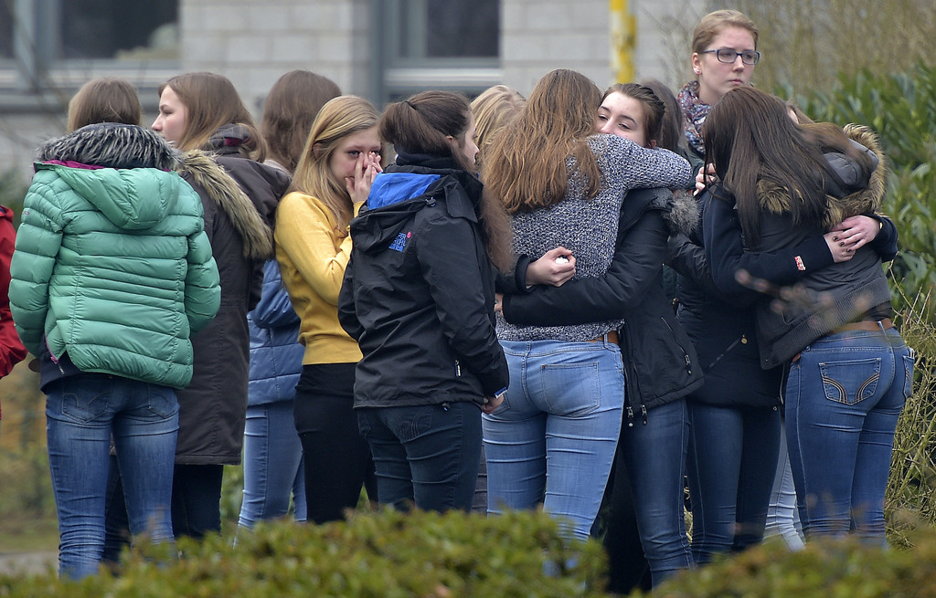 Students mourn in front of the Joseph-Koenig Gymnasium in Haltern, western Germany, Wednesday, March 25, 2015, one day after 16 school children and two teachers were among the 150 victims that died in the Germanwings plane crash in the French alps on the way from Barcelona to Duesseldorf. (AP Photo/Martin Meissner)