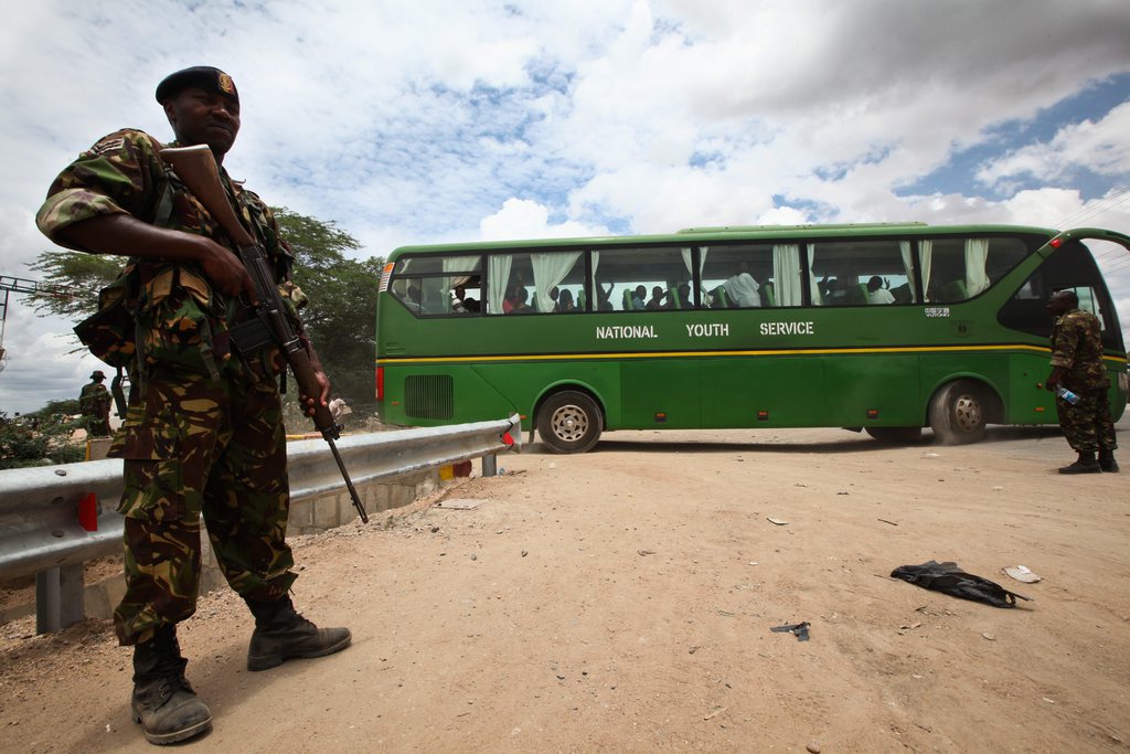 Un soldat kenyan veille ici au départ d'un bus transportant des étudiant survivants du massacre.