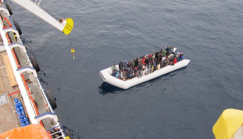 epa04712792 A handout picture made available by German shipping company Opielok Offshore Carriers (OOC) on 20 April 2015 shows a boat with refugees next to the cargo ship 'OOC Cougar' in the Mediterranean sea on 17 January 2015. The ships of the German shipping company Opielok Offshore Carriers have rescued more than 1,500 people in the Mediterranean sea since December 2014.  EPA/Opielok Offshore Carriers Mandatory Credit: Opielok Offshore Carriers HANDOUT EDITORIAL USE ONLY