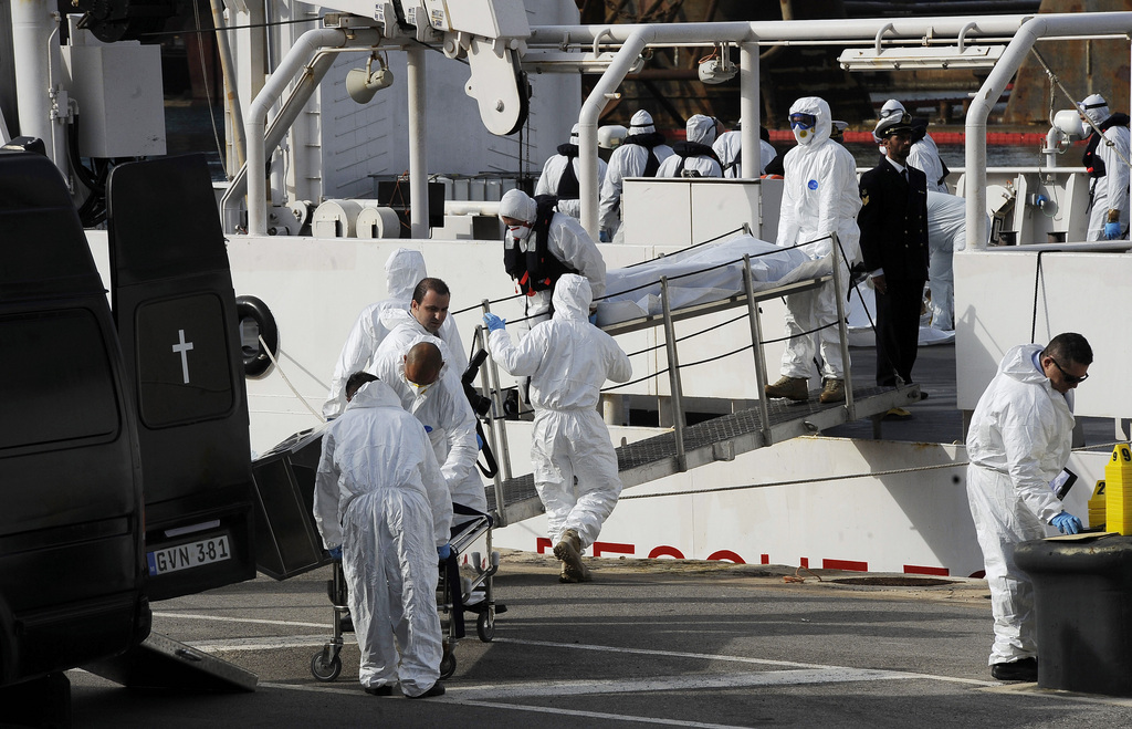 Italian Coast Guard officers disembark the body of a dead migrant off the ship Bruno Gregoretti, in Valletta's Grand Harbour, Monday, April 20 2015. A smuggler's boat crammed with hundreds of people overturned off Libya's coast on Saturday as rescuers approached, causing what could be the Mediterranean's deadliest known migrant tragedy and intensifying pressure on the European Union Sunday to finally meet demands for decisive action. So far rescuers saved 28 people a recovered 24 bodies. (AP Photo/Lino Azzopardi)