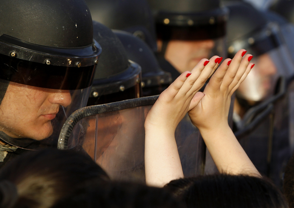 Une femme devant un policier lors des manifestations anti-gouvernementales à Skopje, en Macédoine.
