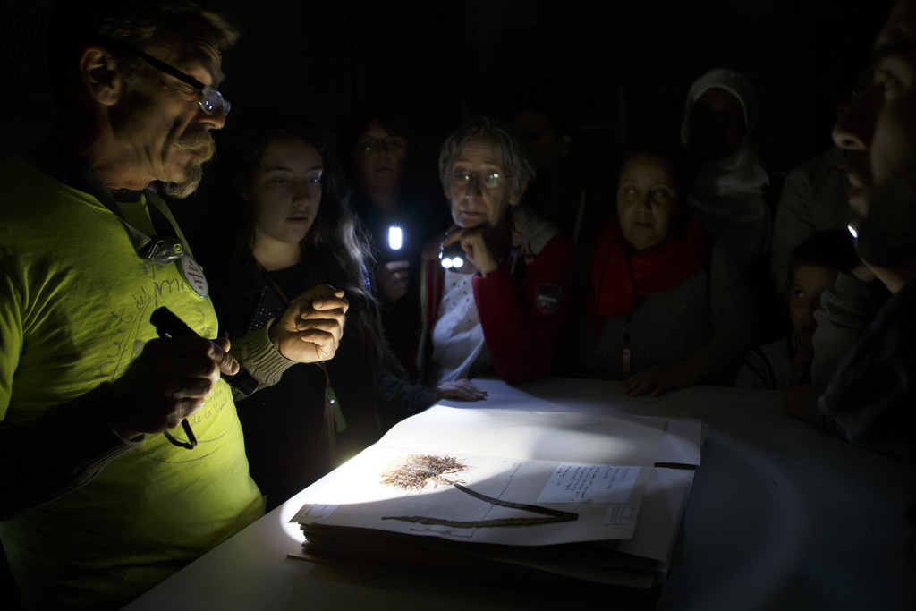 Des personnes participent a une visites a la lampe de poche l'herbier du jardin botanique dans la cadre de la nuit des musees, ce samedi 17 mai 2015 a Geneve.