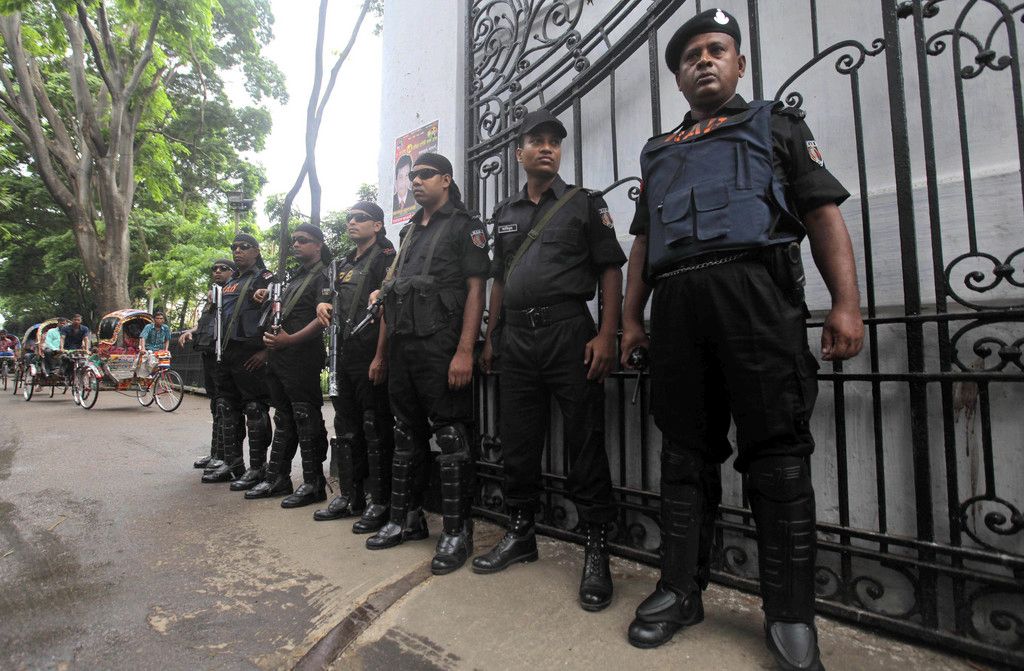 Bangladeshi security personnel stand guard in front of a court where a verdict against Jamaat-e-Islami party leader Abdul Quader Mollah is to be delivered in Dhaka, Bangladesh, Tuesday, Sept. 17, 2013. Bangladesh's Supreme Court on Tuesday sentenced Mollah to death for committing crimes against humanity during the nation's 1971 independence war against Pakistan. (AP Photo/A.M. Ahad)
