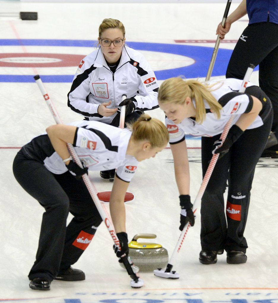 Switzerland's Alina Paetz, top, watches the rock as her teammates sweep the way during the first end as the team plays Japan in the women's World Curling Championships in Sapporo, northern Japan, Saturday, March 14, 2015. (AP Photo/Kyodo News, Ryosuke Uematsu) JAPAN OUT, MANDATORY CREDIT