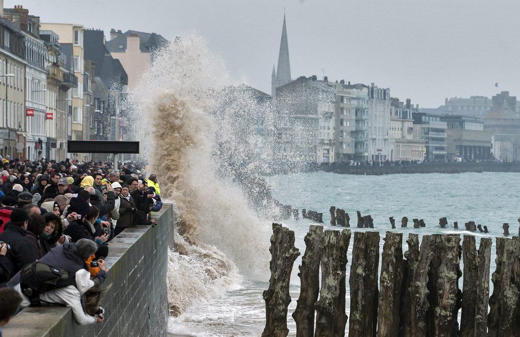 epa04672482 Large waves crash over the crowded waterfront during the incoming tide in Saint Malo, France, 21 March 2015. The northern and western coasts of France are experiencing high tidal coefficients (reaching up to coefficient 119), earning this weekend's tides the nickname 'tide of the century'.  EPA/IAN LANGSDON