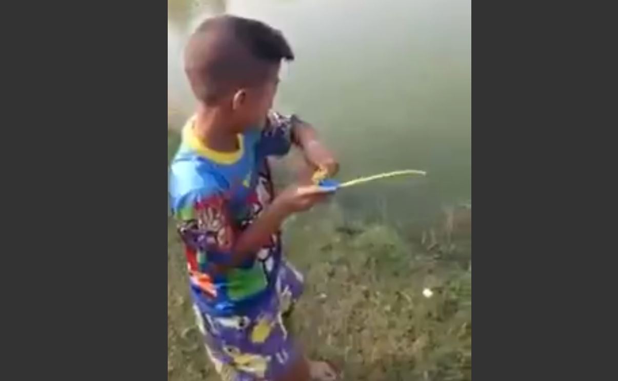 La canne à pêche de ce jeune garçon ne paie pas de mine. Mais elle va lui permettre de faire une belle prise.