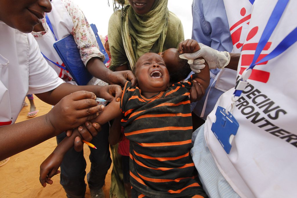 epa03792079 (FILE) A file photograph dated 01 August 2011 shows a Somali refugee boy crying as he receives a vaccination shot by Medecins Sans Frontieres (MSF) staff outside the Ifo camp, one of three camps that make up sprawling Dadaab refugee camp in Dadaab, northeastern Kenya. MSF announced on 18 July 2013 that two Spanish aid workers of MSF, Montserrat Serra and Blanca Thiebaut,  who were abducted from the Dadaab refugee camp in Kenya on 13 October 2011, have been freed in Somalia.  EPA/DAI KUROKAWA