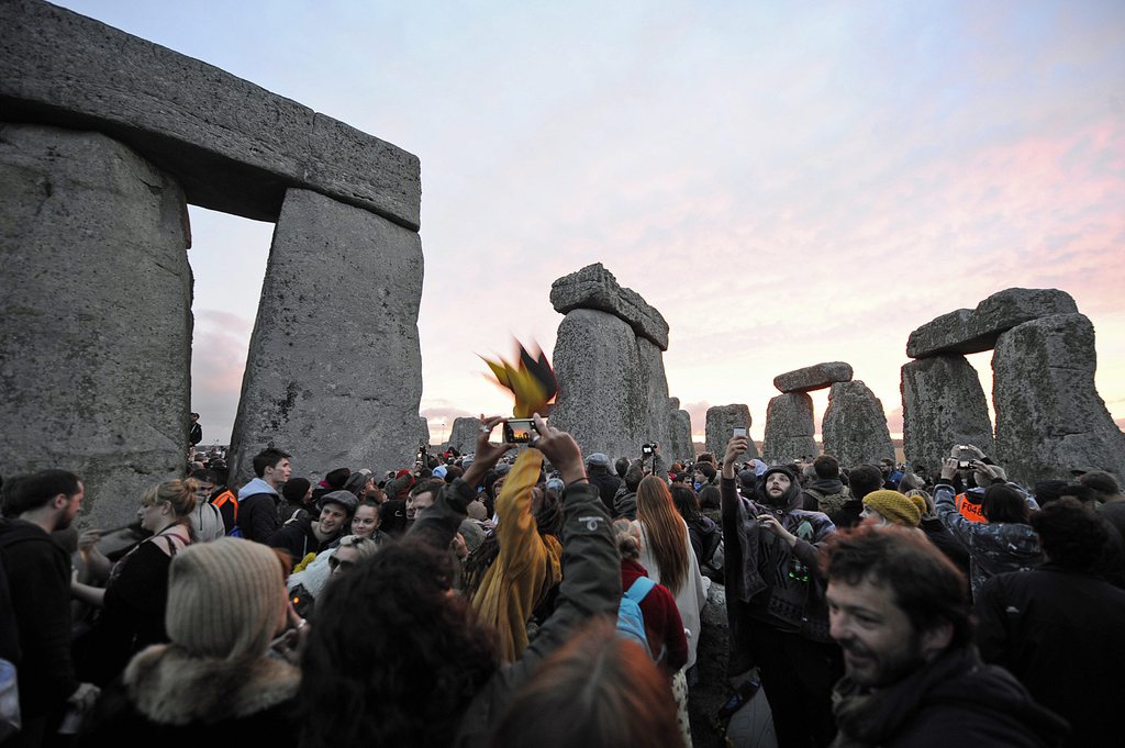 epa04811910 Revellers welcome the dawning of the summer solstice through cloudy skies, at the historic world heritage site of Stonehenge near Salisbury, Whiltshire,  Britain, 21 June 2015.  EPA/GERRY PENNY -