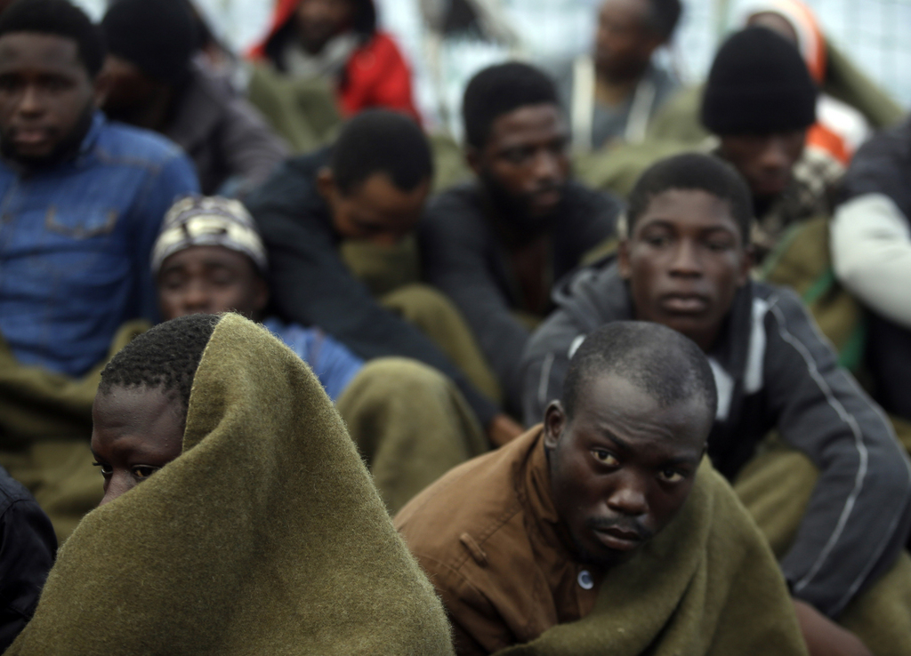 Migrants sit on the deck of the Belgian Navy vessel Godetia after they were saved at sea during a search and rescue mission in the Mediterranean Sea off the Libyan coasts, Wednesday, June 24, 2015. Hundreds of migrants were rescued on Tuesday by the Godetia, which is part of a EU Navy vessels fleet taking part in the Triton migrants rescue operation. (AP Photo/Gregorio Borgia)