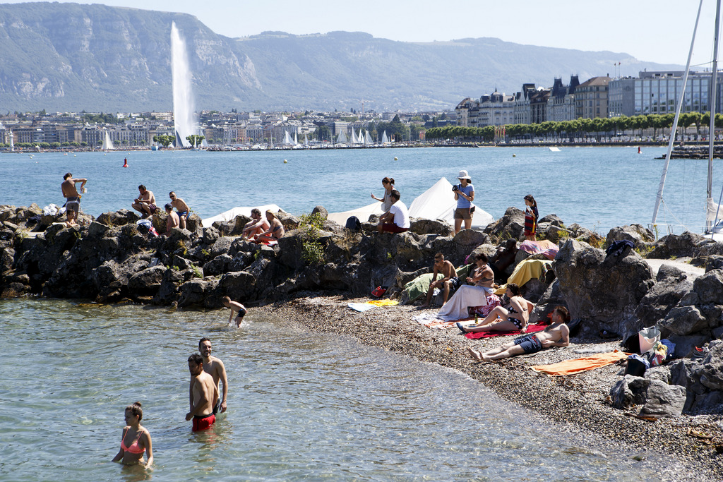 People enjoy the water and the sun with the famous fountain "Jet d'eau" in the back ground on the bank of the lake of Geneva, in Geneva, Switzerland, Sunday, June 28, 2015. (KEYSTONE/Salvatore Di Nolfi)
