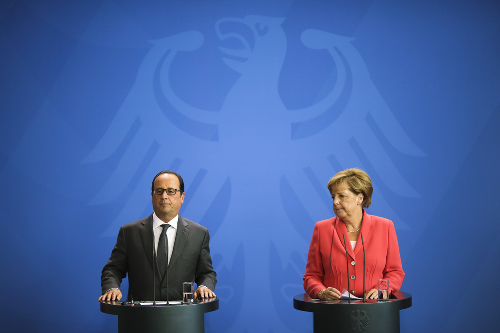 German Chancellor Angela Merkel, right, and French President Francois Hollande brief the media about the European migrant crisis prior to a meeting at the chancellery  in Berlin, Monday, Aug. 24, 2015. (AP Photo/Markus Schreiber).