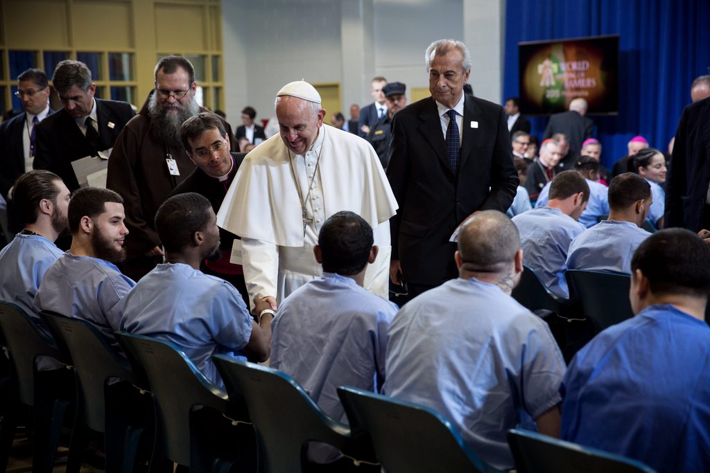 Le pape François bénit des prisonniers.