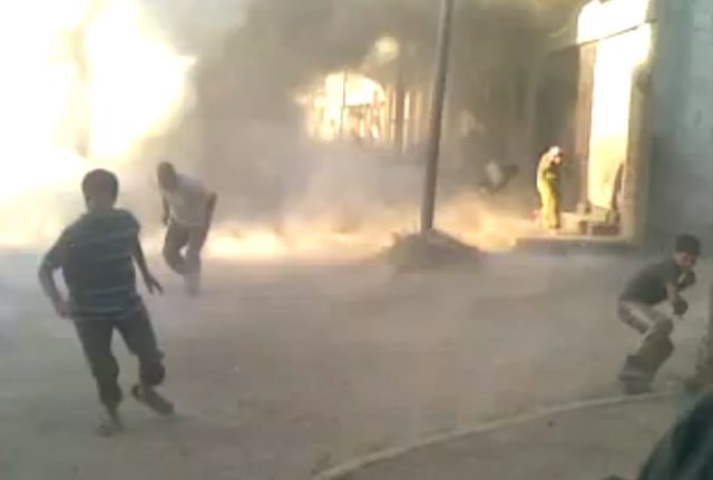 This frame grab made from an amateur video provided by Syrian activists on Monday, May 28, 2012, purports to show the massacre in Houla on May 25 that killed more than 100 people, many of them children. The amateur footage shows people running along a street, purportedly just after the attack on Houla started. (AP Photo/Amateur Video via AP video) THE ASSOCIATED PRESS IS UNABLE TO INDEPENDENTLY VERIFY THE AUTHENTICITY, CONTENT, LOCATION OR DATE OF THIS CITIZEN JOURNALISM IMAGE