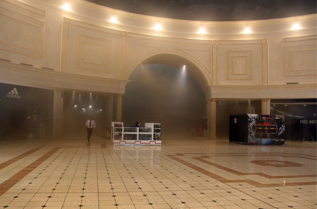 A man runs through smoke in the Villaggio Mall, in Doha's west end, as a fire took hold of the upscale mall in the Qatari capital of Doha Monday May 28, 2012. Qatar's Interior Ministry said 13 children were among 19 people killed in a fire that broke out at one of the Gulf state's fanciest shopping mall on Monday. The Villaggio opened in 2006 and is one of Qatar's most popular shopping and amusement destinations. It includes an ice skating rink and indoor Venice-style gondola rides. (AP Photo/Osama Faisal)