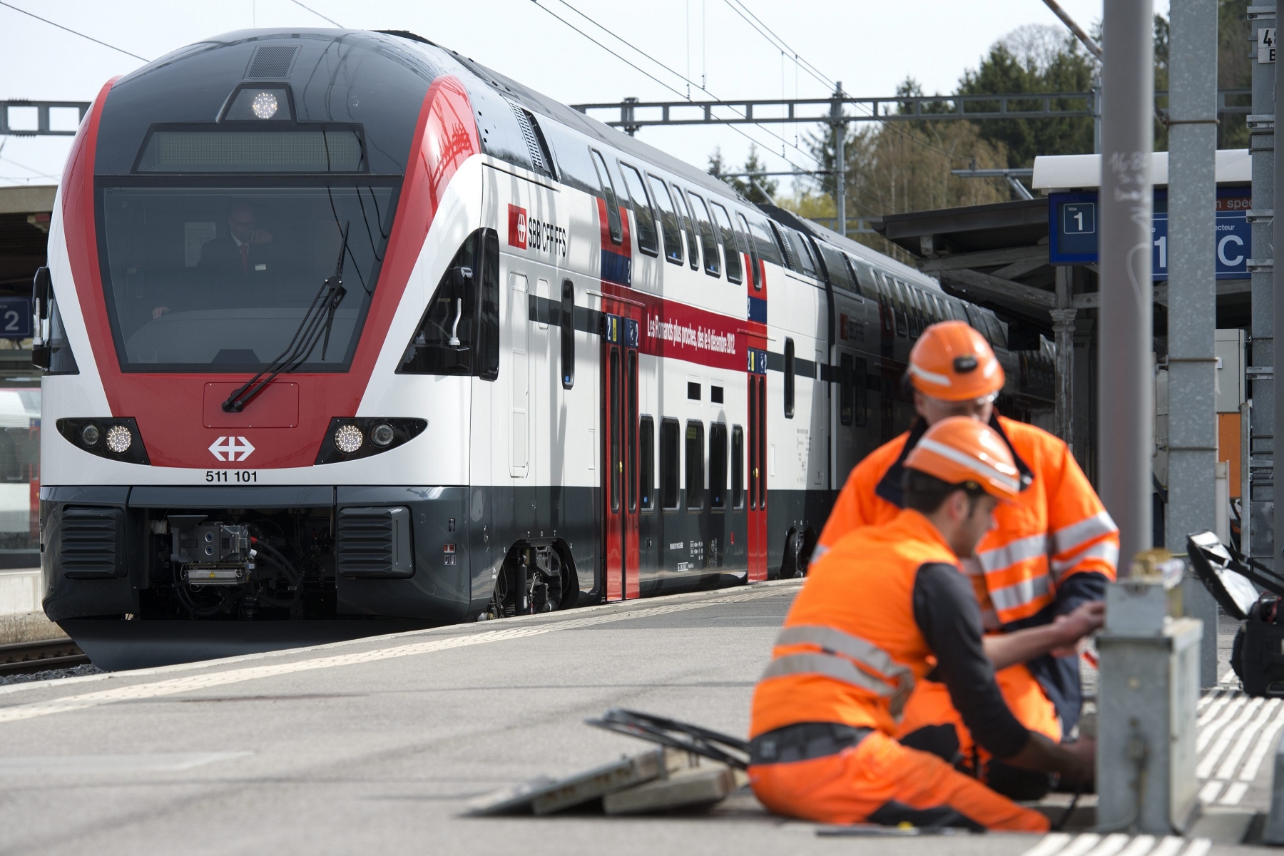 Des ouvriers des CFF travaillent devant un train Duplex Regio a quai lors du voyage inaugural des nouvelles rames Duplex Regio CFF en Suisse romande, ce jeudi 26 avril 2012 a Romont. Les Chemins de Fer Federaux, CFF, ont mis en service le train a deux niveaux Duplex Regio CFF.