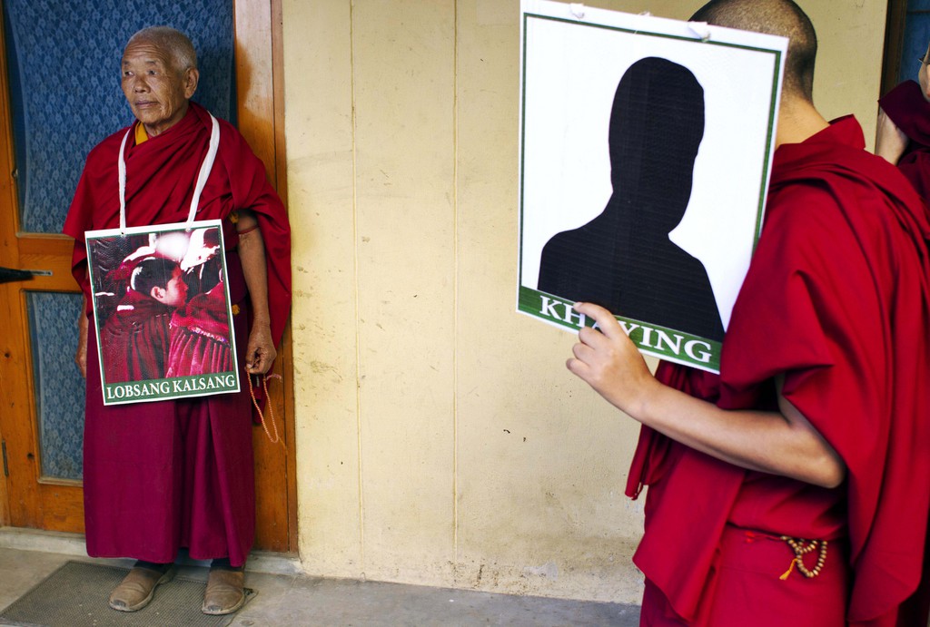 Des moines tibétains montrent les portraits de frères qui se sont immolés.