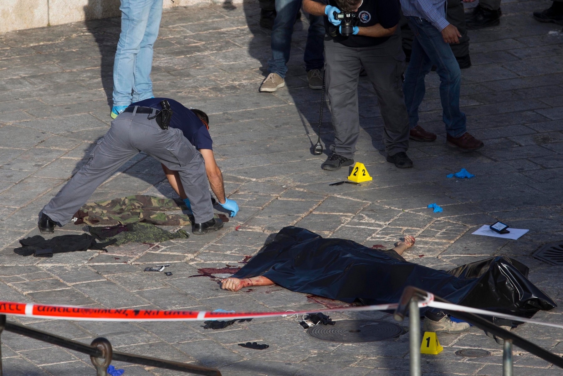 epa04977431 Israeli police work at the scene as emergency teams remove the body of a Palestinian man who was shot by the Israeli Police after he tried to stab them at the Damascus gate in the Old city of Jerusalem, Israel, 14 October 2015. According to media reports, hundreds of troops were being deployed in Israeli cities following a series of shooting and stabbing attacks by Palestinians.  EPA/ABIR SULTAN ATTENTION EDITORS: PICTURE CONTAINS GRAPHIC CONTENT ISRAEL PALESTINIAN CONFLICTS
