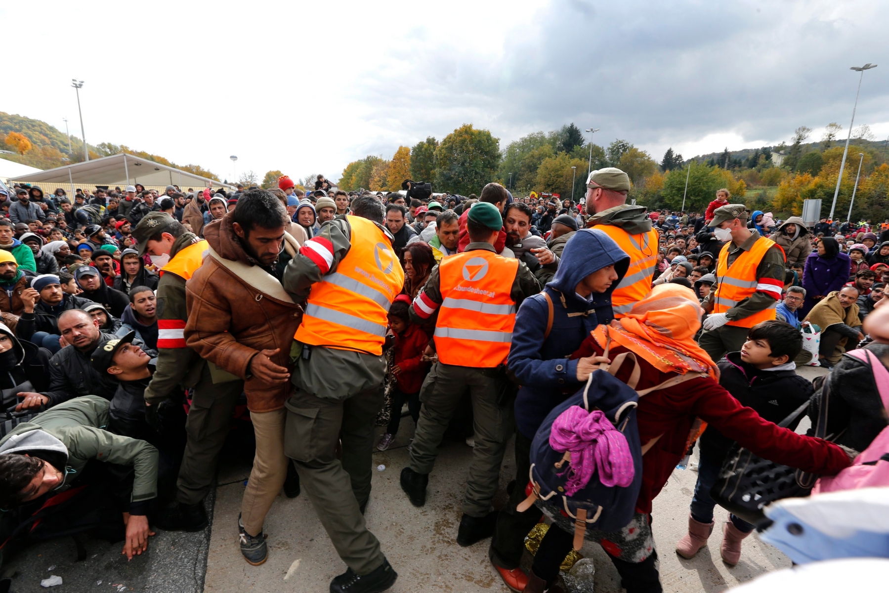 epa04989016 Austrian soldiers try and control migrants waiting to cross the border between Slovenia and Austria near Spielfield, Austria, 22 October 2015. Police had to open security fences in order to guarantee security for some 2.000 refugees waiting to enter Austria. Europe must boost security on its outer borders in the face of the brewing refugee crisis while finding a way to stay true to its values, delegates at a meeting of European conservative parties argued 21 October 2015.  EPA/ANTONIO BAT AUSTRIA  REFUGEES MIGRATION CRISIS