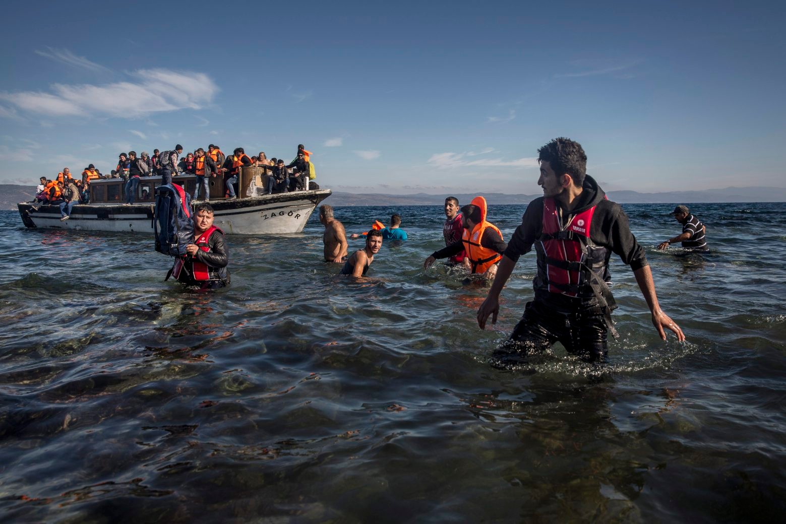 Refugees from Syria and Iraq disembark on the Greek island of Lesbos after arriving with other 120 people on a wooden boat from the Turkish coast, Monday, Oct. 26, 2015. Greeces government says it is preparing a rent-assistance program to cope with a growing number of refugees, who face the oncoming winter and mounting resistance in Europe.(AP Photo/Santi Palacios) Greece Migrants
