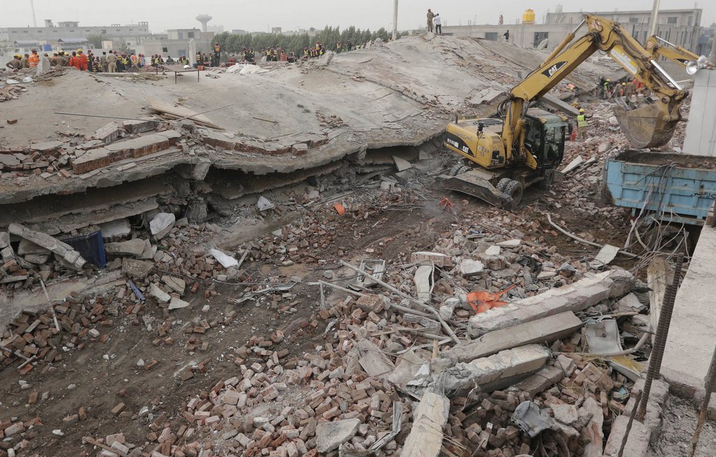 Des soldats de l'armée pakistanaise et des secouristes recherchent encore des survivants au milieu des décombres de l'usine.