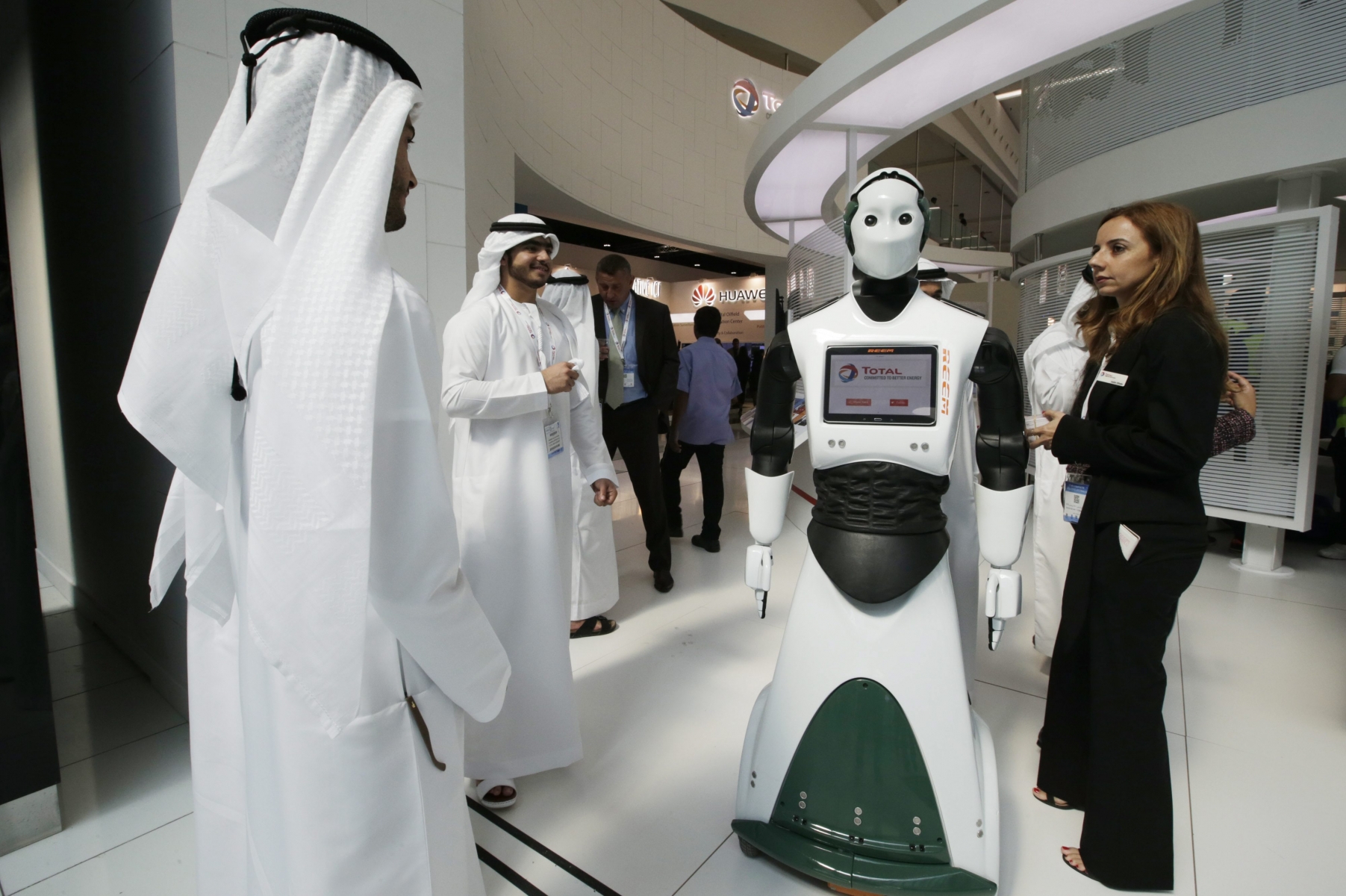epa05017923 An exhibitor (R) speaks about a robot at Total section at the exhibition of Abu Dhabi International Petroleum Exhibition and Conference (ADIPEC) in Abu Dhabi, United Arab Emirates, 09 November 2015.  ADIPEC, a meeting place of the international oil and gas community, runs between 09 and 12 November 2015.  EPA/ALI HAIDER