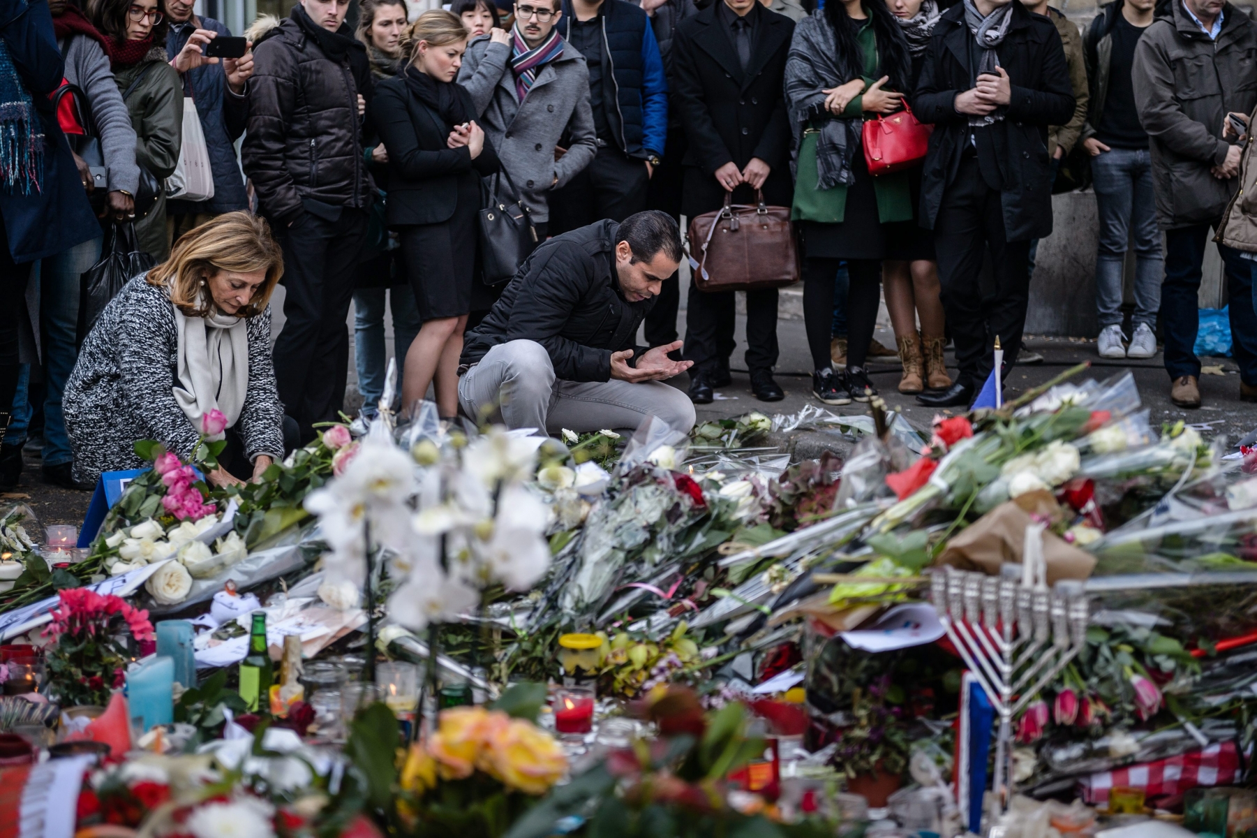 epa05028438 A muslim man is praying while people lay flowers and candles in front of the memorial set near the Bataclan concert venue in Paris, France, 16 November 2015. More than 130 people were killed and hundreds injured in the terror attacks which targeted the Bataclan concert hall, the Stade de France national sports stadium, and several restaurants and bars in the French capital on 13 November. Authorities believe that three coordinated teams of terrorists armed with rifles and explosive vests carried out the attacks, which the Islamic State (IS) extremist group has claimed responsibility for.  EPA/CHRISTOPHE PETIT TESSON FRANCE  PARIS ATTACKS AFTERMATH