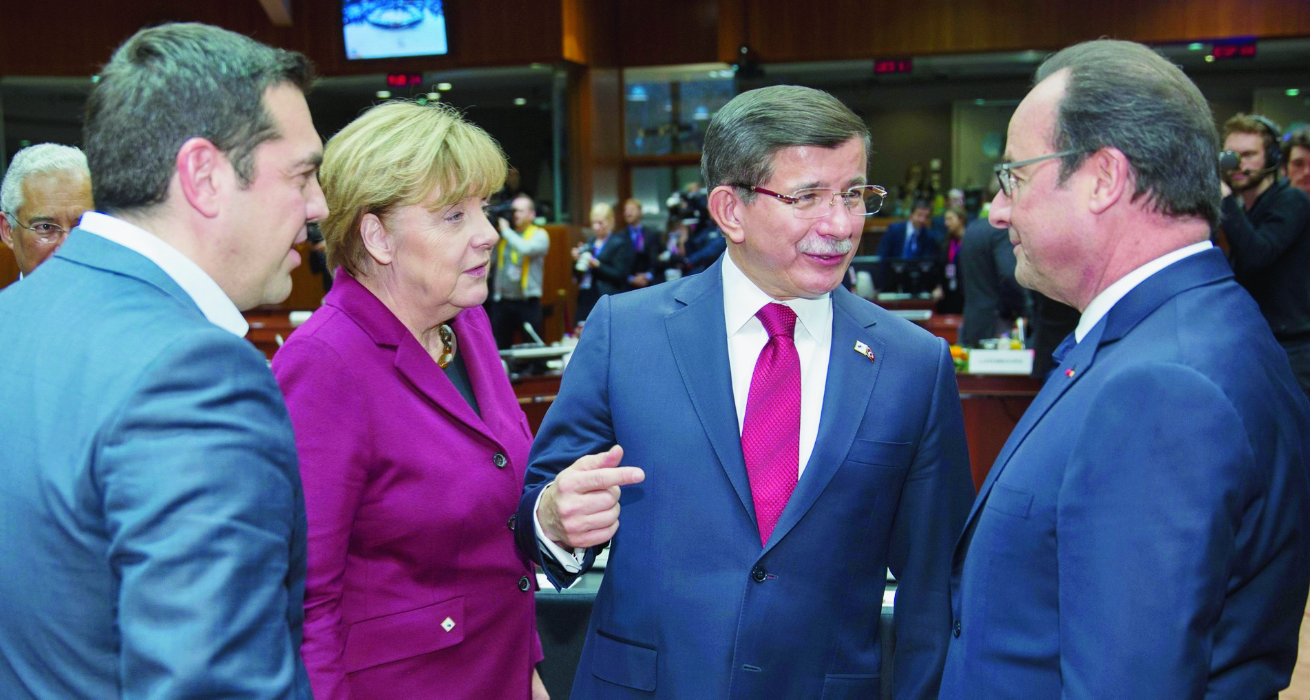 epa05047819 (L-R) Greek Prime Minister Alexis Tsipras, German Chancellor Angela Merkel chats with Turkish Prime Minister Ahmet Davutoglu and French President Francois Hollande, at the start of an extraordinary EU Summit with Turkey in Brussels, Belgium, 29 November 2015. The European Union hopes to secure Ankara's concrete help in stemming a surge in migration, at a joint summit in Brussels, with the bloc offering financial aid and closer ties in return. Europe is facing its largest people movements since World War II, with almost 900,000 migrants and asylum seekers arriving this year. Many, including large numbers from war-torn Syria, transit through Turkey and board boats headed for Greece.  EPA/OLIVIER HOSLET BELGIUM EU TURKEY SUMMIT