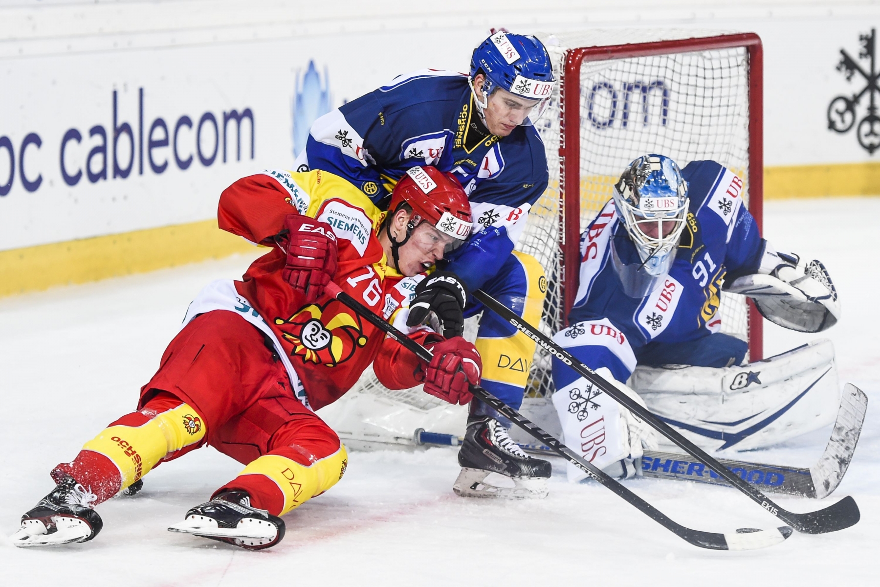 Helsinki's Jere Sallinen, left, fights for the puck with Davos' Silvio Schmutz and goalkeeper Gilles Senn, during the game between Finland's Jokerit Helsinki and Switzerland's HC Davos, at the 89th Spengler Cup ice hockey tournament in Davos, Switzerland, on Tuesday, December 29, 2015. (KEYSTONE/Gian Ehrenzeller)