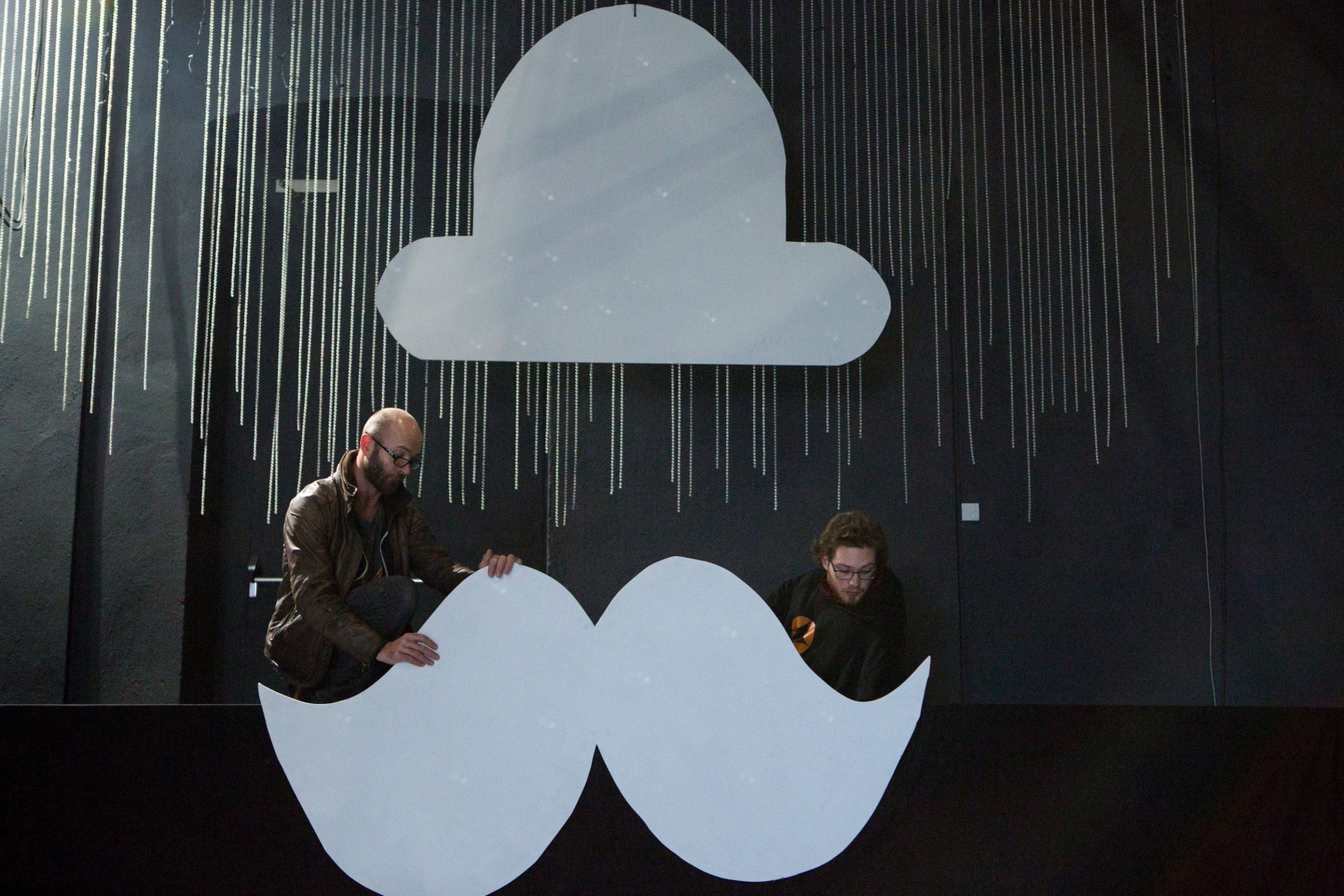 Les techniciens Luc Gros et Damien Junod installent la grande moustache à la cabine des dj's pour la soirée du Nouvel an de l'Usine à Gaz sur le thème "Black and White".