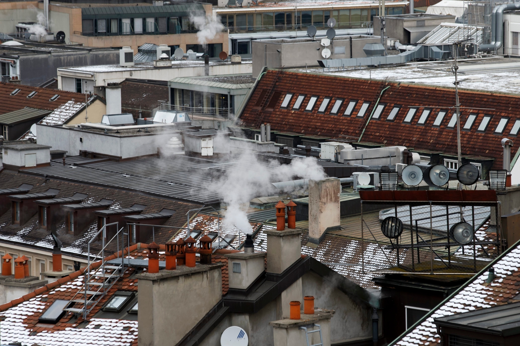 Les fumees s'echappent des cheminees sur les toits de la ville, ce lundi 18 janvier 2016 a Geneve. Le gouvernement genevois entend mettre en place une veritable strategie pour ameliorer la qualite de l'air dans le canton. Des objectifs chiffres de diminution des emissions polluantes ont ete fixes. D'ici a 2030, Geneve vise une reduction de 50 pourcent des emissions d'oxydes d'azote et de 18 pourcent des particules fines, a explique lundi devant la presse le conseiller d'Etat Luc Barthassat. Pour parvenir a ces resultats, plusieurs pistes ont ete evoquees, mais aucune decision n'a pour l'instant ete prise. (KEYSTONE/Salvatore Di Nolfi) SCHWEIZ GENF LUFTQUALITAET STRATEGIE