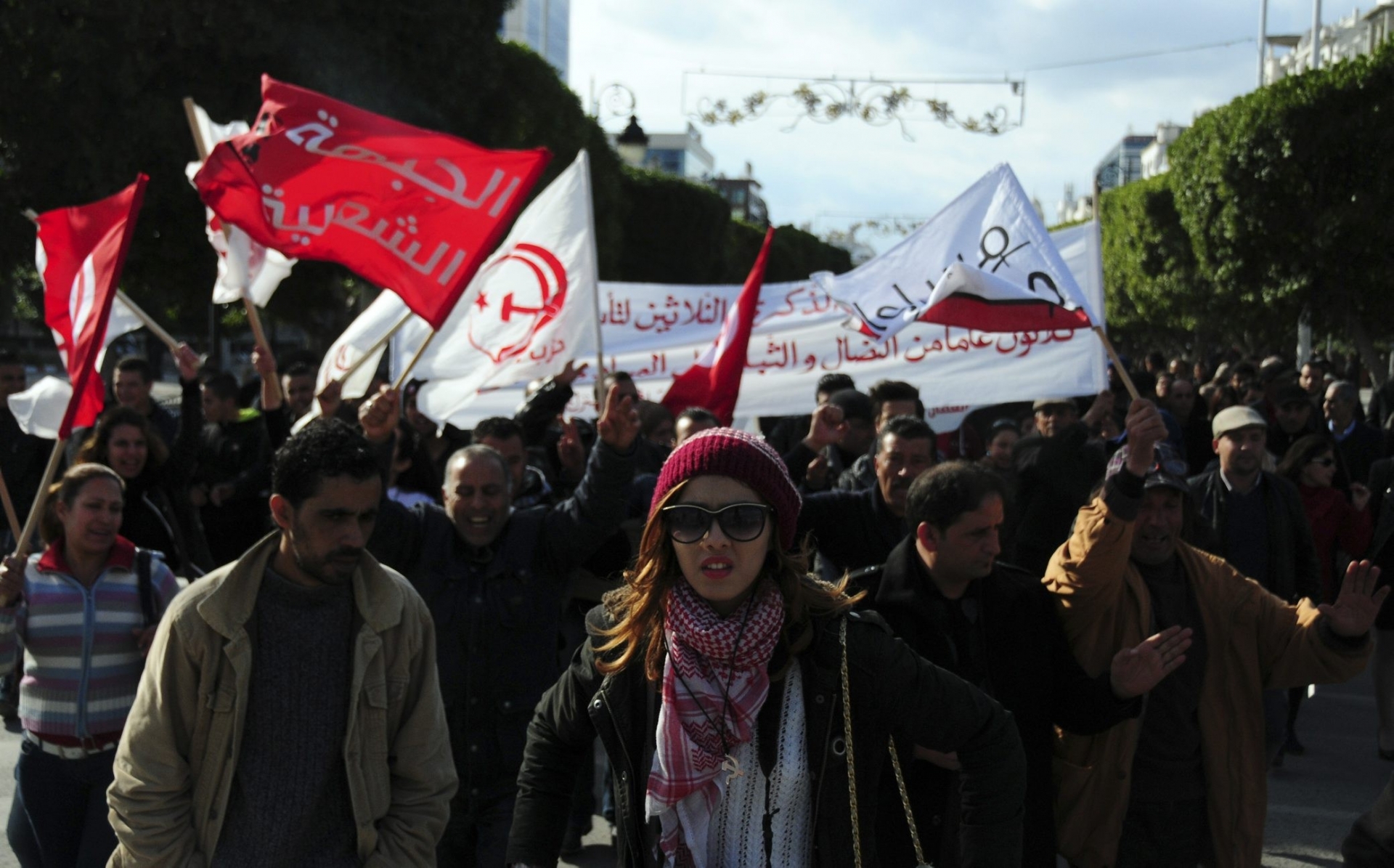 Unemployed tunisian people stage a protest in a precarious calm enforced by a nationwide curfew in Habib Bourguiba avenue, center downtown of Tunis, Saturday Jan. 23, 2016.  Tunisia's president vowed Friday to end the cycle of unrest that has pummeled towns across the country as authorities imposed a nationwide curfew, five years after the nation, convulsed by protests, overthrew its longtime ruler and moved onto the road to democracy. (AP Photo/Riadh Dridi) TUNISIA