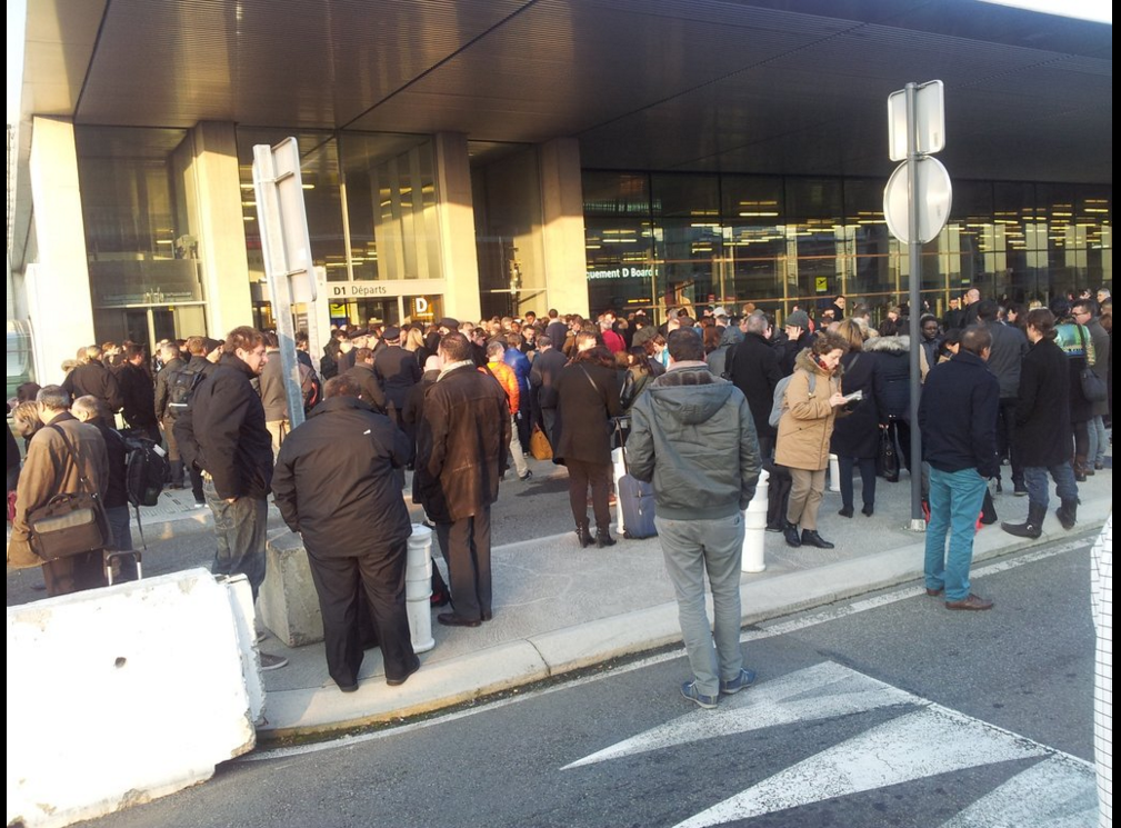 Les passagers de l'aéroport patientent devant le bâtiment de l'aéroport de Toulouse.