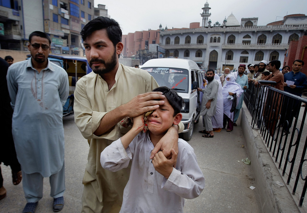 Un homme conduit à l'hôpital un enfant blessé à Peshawar, au Pakistan. Au moins 20 maisons ont été détruites dans le nord-ouest du pays.