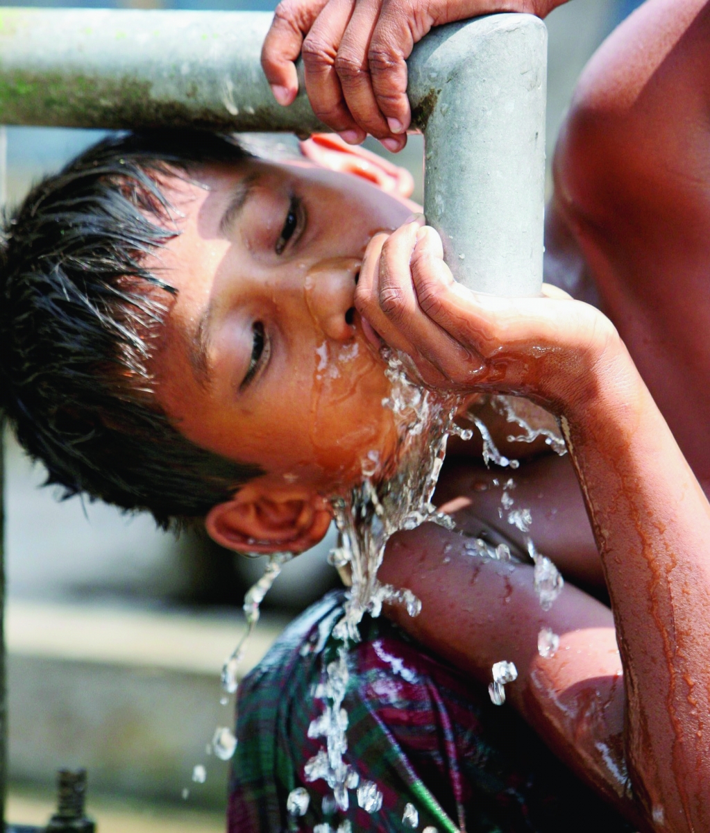 A Bangladeshi boy drinks water from a roadside water tap in Dhaka, Bangladesh, Saturday, March 21, 2009, ahead of World Water Day. There is no direct supply of potable water at homes in most of the poor neighborhoods and people have to depend on regulated supply of water from public taps erected on roadsides, with a single tap catering to hundreds of households. (AP Photo/Pavel Rahman) Bangladesh World Water Day