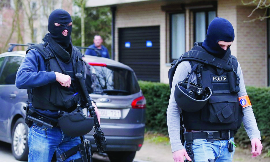 epa05213035 Police officers take position during a police operation in Forest, Brussels, Belgium, 15 March 2016. A major police operation was underway after shots were fired during an anti-terror raid in Brussels. Three officers were lightly injured, police said. The raid was linked to the 13 November Paris Attacks. It was confirmed by the French Interior Minister that French Police were taking part in the operation alongside their Belgian colleagues.  EPA/LAURENT DUBRULE BELGIUM POLICE RAID SHOOTOUT