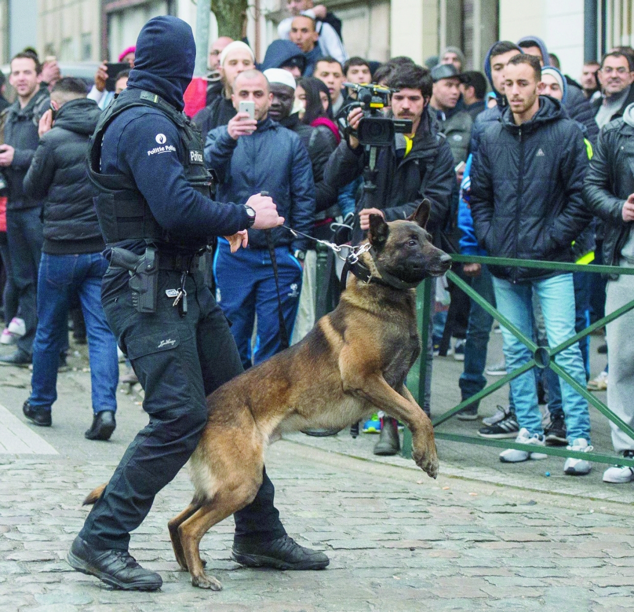 epa05218780 A Belgian police dog handler holds back curious onlookers during an anti-terror operation in the Molenbeek neighborhood of Brussels, Belgium, 18 March 2016. Media reports claim that fugitive terror suspect Salah Abdeslam has been wounded but arrested alive during the anti-terror operation in Molenbeek that was carried out within the investigations linked to last year's Paris terror attacks.  EPA/STEPHANIE LECOCQ BELGIUM TERRORIST RAID