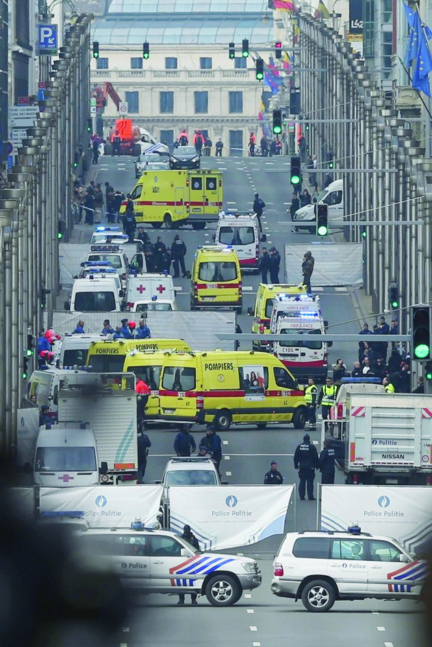 epa05225321 Emergency workers at Rue de la Loi, after an explosion at Maelbeek Metro station, Brussels, Belgium, 22 March 2016. A double explosion in the departure hall of Zaventem Airport in Brussels has left at least 13 dead and 35 wounded, sources at the General Attorney's Office of Belgium said. Hours later, blasts also rocked Shuman and Maelbeek metro stations near European Union buildings, the number of victims which remains unknown, prompting a shutdown of the metro system as authorities raised the city terror alert to the maximum level.  EPA/OLIVIER HOSLET BELGIUM BRUSSELS METRO EXPLOSION