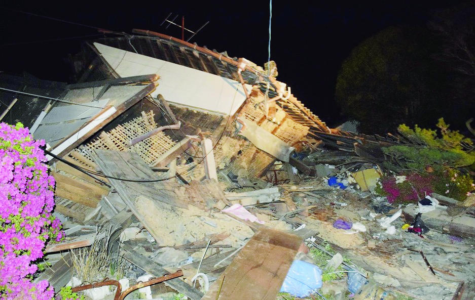 A house collapses following the earthquake in Mashiki, near Kumamoto city, southern Japan,  early Friday, April 15, 2016.  Rescuers in southern Japan are searching for trapped residents in at least two dozen collapsed houses, after a powerful earthquake struck. (Yuta Iida/Kyodo News via AP) JAPAN OUT, MANDATORY CREDIT Japan Earthquake