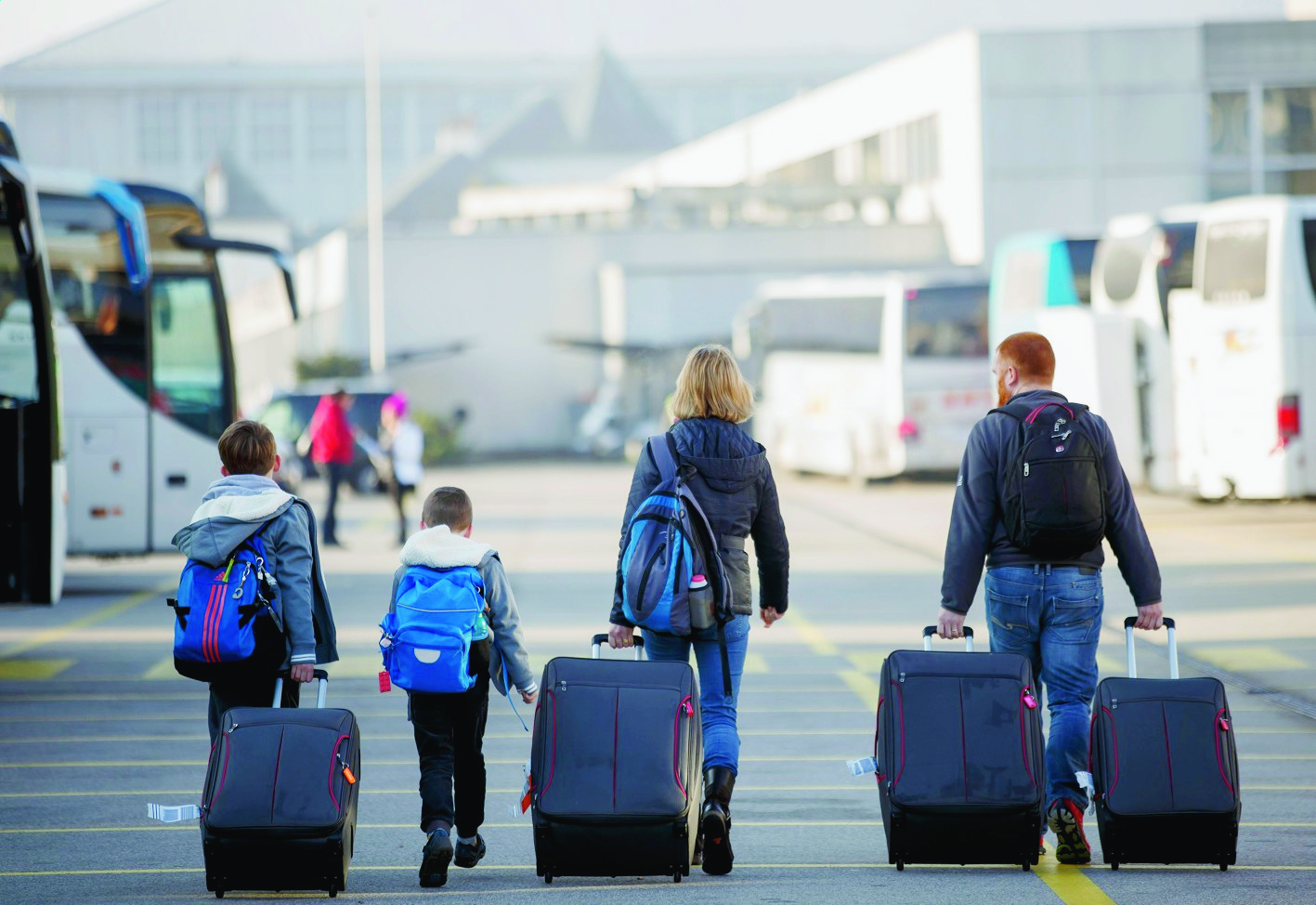 Flight passengers, with their luggages and ski bags, walk in front of the terminal 2 of the Geneva Airport, in Geneva, Switzerland, Saturday, December 26, 2015. Thousands of skiers and travelers are expected during this week at the airport to celebrate New Year in ski resorts of Switzerland or in ski resorts of France. (KEYSTONE/Salvatore Di Nolfi) SWITZERLAND GENEVA AIRPORT