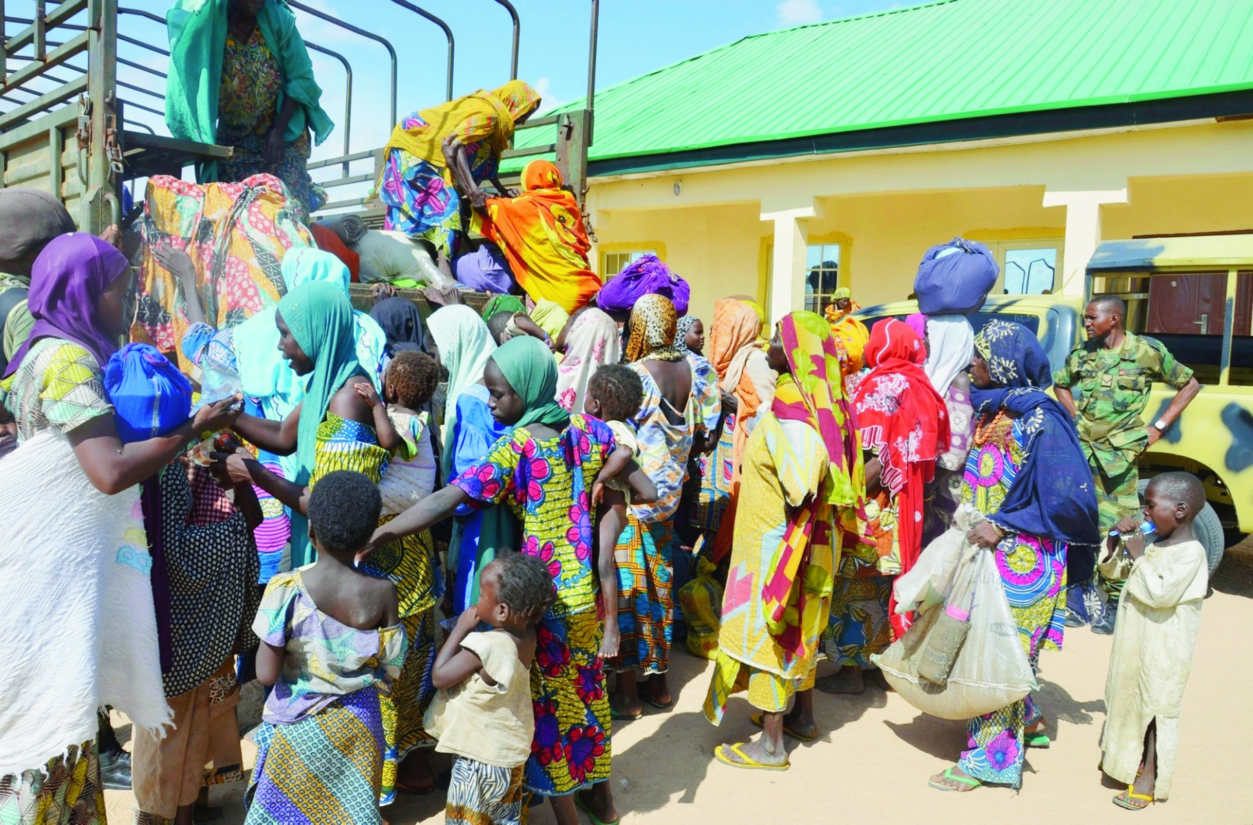 FILE - In this July 30, 2015, file photo, women and children rescued by Nigerian soldiers from the Islamic extremist group Boko Haram in the northeast of Nigeria, arrive at the military office in Maiduguri, Nigeria. A video appearing to show proof of life of some of Nigeria's kidnapped Chibok girls is being aired, Wednesday, April 13, 2016, along with images of tearful parents recognizing their daughters, unheard of since the mass abduction by the Boko Haram two years ago. (AP Photo/Jossy Ola, File) Nigeria Kidnapped Girls