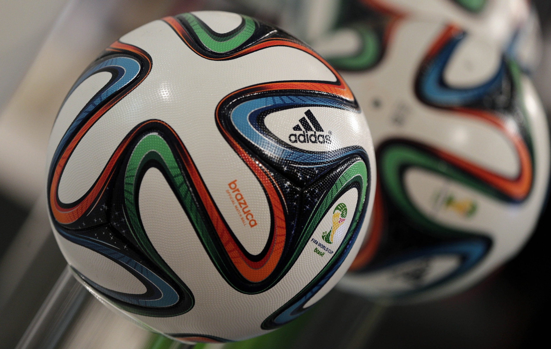 The adidas logo is printed on "Brazuca", the official FIFA World Cup 2014 soccer ball, during the annual shareholders meeting in Fuerth, Germany, Thursday, May 8, 2014. In the first quarter of 2014, Group revenues remained stable on a currency-neutral basis. Currency translation effects had a significant negative impact on sales in euro terms. Group revenues decreased 6% to euro 3.533 billion in the first quarter of 2014 from euro 3.751 billion in 2013. (AP Photo/Matthias Schrader) Germany Earns Adidas