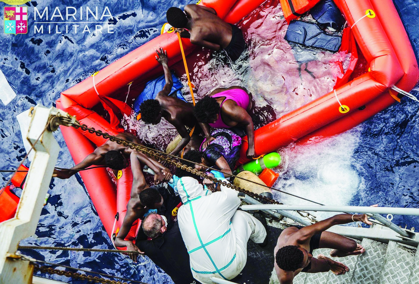 In this photo taken in the Mediterranean Sea, off the Libyan coast, Friday, May 27, 2016 rescuers help migrants to board the Italian Navy ship Vega, after the boat they were aboard sunk. The Italian navy says it has saved 135 migrants from a sinking boat and recovered 45 bodies in the Mediterranean. (Raffaele Martino/Marina Militare via AP Photo) Italy Migrants