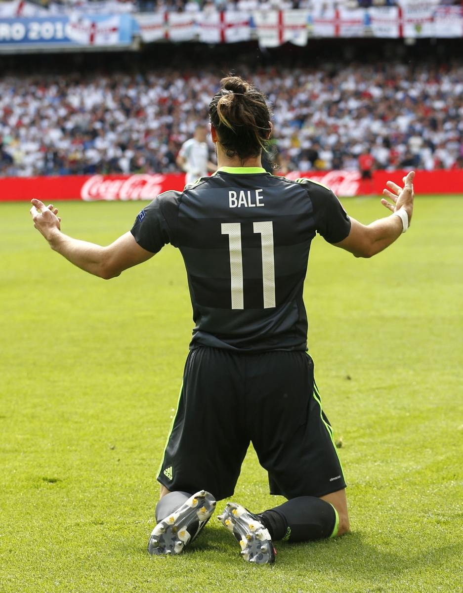 Wales' Gareth Bale opens his arms as he kneels on the pitch during the Euro 2016 Group B soccer match between England and Wales at the Bollaert stadium in Lens, France, Thursday, June 16, 2016. (AP Photo/Darko Vojinovic)