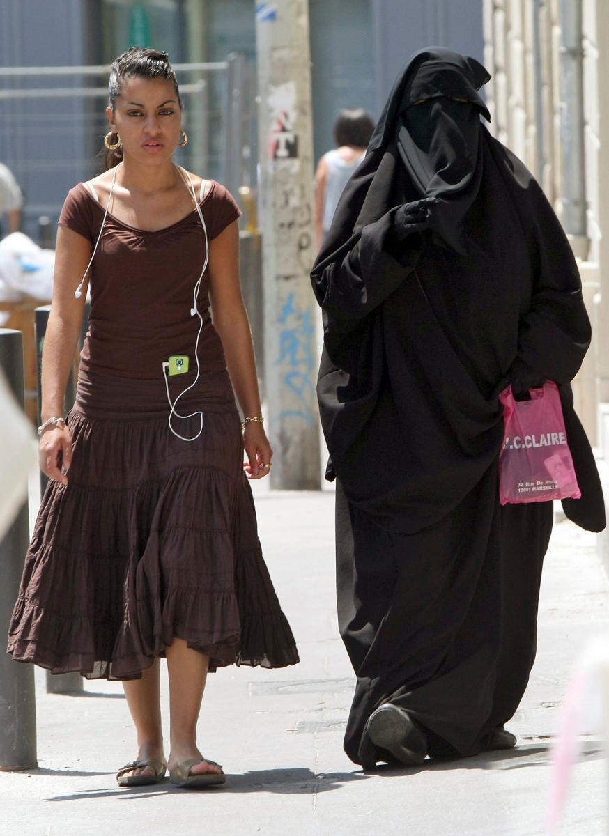 Two women, one wearing the niqab, a veil worn by the most conservative Muslims that exposes only a woman's eyes, right, walk side by side, in the Belsunce district of downtown Marseille, central France, Friday June 19, 2009. The French government's spokesman says he favors the creation of a parliamentary commission to study the small but growing trend of burqa wear in France. Luc Chatel says the commission could possibly propose legislation aimed at banning the burqa and other fully covering garments worn by some Muslim women. (KEYSTONE/AP Photo/Claude Paris) FRANCE BURQA