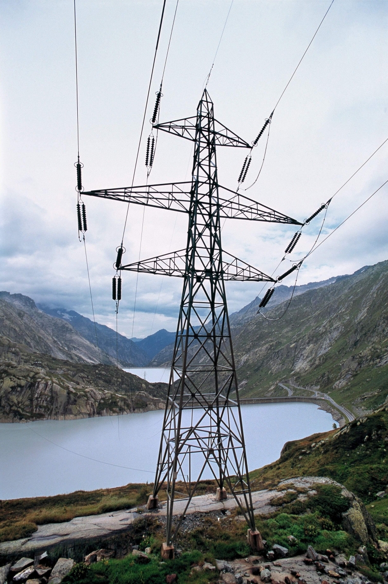 ARCHIV --- Der Grimselsee, der das Kraftwerk Oberhasli KWO speist, im Vordergrund ein Strommast, aufgenommen am 27. August 2002. - Neue Hochspannungsleitungen gehoeren unter den Boden. Der Walliser CVP-Staenderat Jean-Rene Fournier praesentierte am Montag, 14. April 2008 in Bern seine von 26 Mitgliedern der kleinen Kammer mitunterzeichnete Motion, welche den Bundesrat beauftragt, praezise Kriterien festzulegen, wann eine Hochspannungsleitung vergraben werden muss. (KEYSTONE/Gaetan Bally)  SCHWEIZ ERDVERLEGUNG VON HOCHSPANNUNGSLEITUNGEN