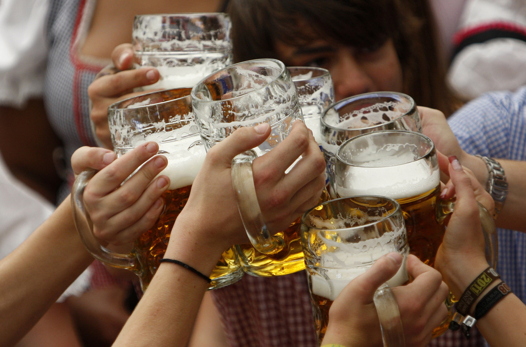 Visitors lift their beer mugs in the Hofbraeuhaus-tent after the opening of the famous Bavarian "Oktoberfest" beer festival in a beer tent in Munich, southern Germany, on Saturday, Sept.17, 2011. The world's largest beer festival, to be held from Sept. 17 to Oct. 3, 2011 will see some millions visitors. (AP Photo/Matthias Schrader)